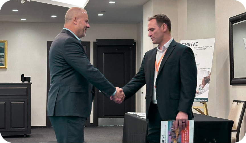 Ed Regis (medent) and Eric McElvenny shake hands at the THRiVE Healthcare Summit in Pittsburgh.